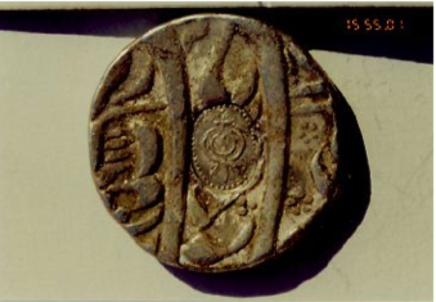 The counter strike of <em>deg teġ</em> emblem on a Mughal coin of 1699